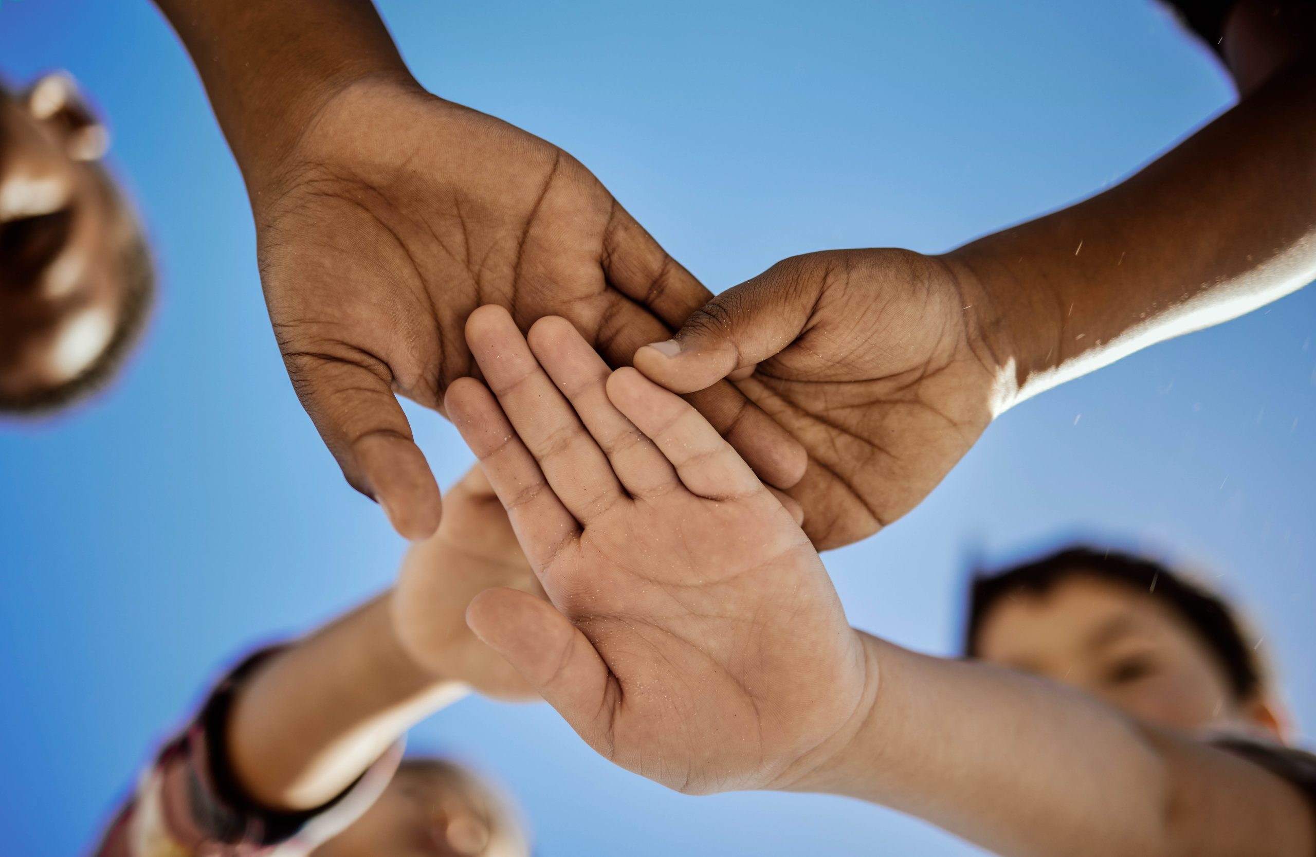 Diversity, stack of hands and children in unity, support or soli